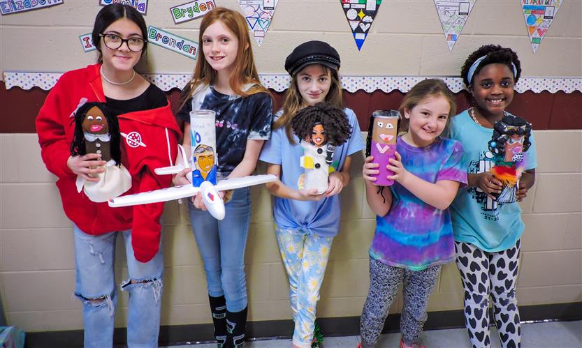 Students hold up Characters in a Can